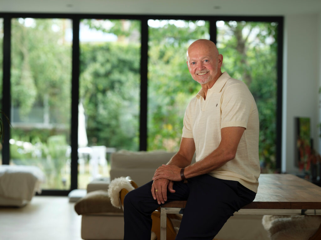 Toni Coppers portret in warm zijlicht, woonkamer met tuinzicht